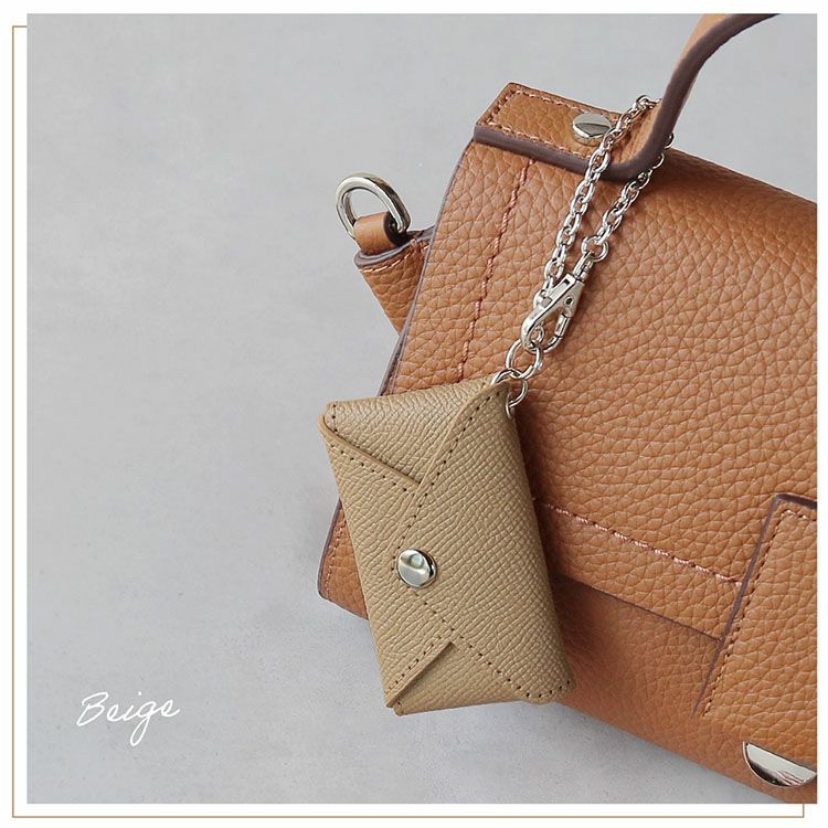 明るいブルーの内側で遊び心のあるベージュバッグチャーム